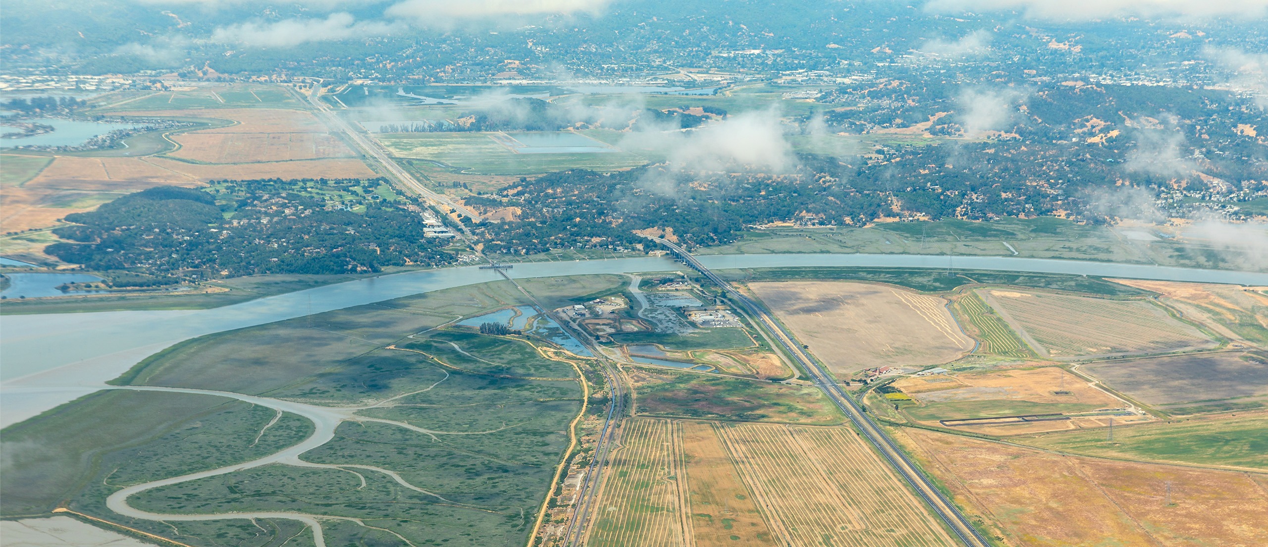 Aerial view of a marsh and farmland along a river
